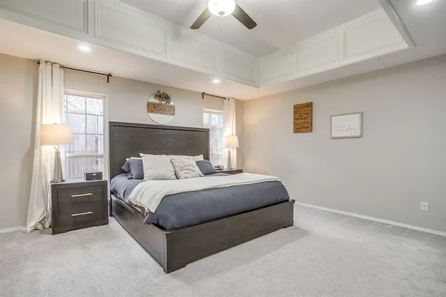 a spacious bedroom with a bed and a ceiling fan