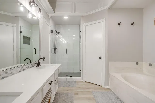 a spacious bathroom with a bathtub shower sink and mirror