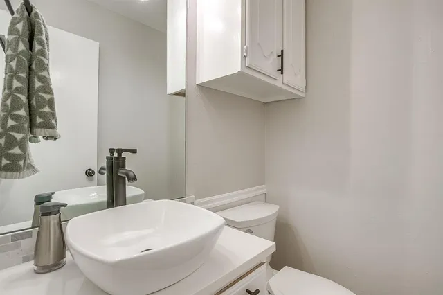 a bathroom with a sink a toilet and mirror