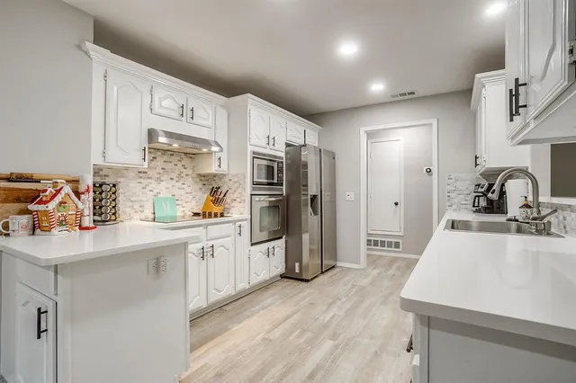 a kitchen with stainless steel appliances a sink stove and refrigerator