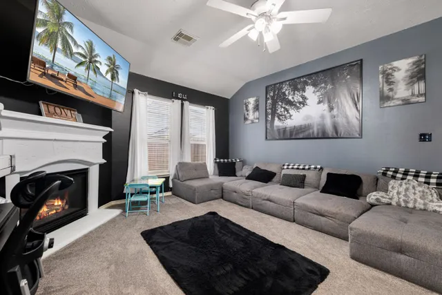 a living room with furniture a fireplace and a flat screen tv