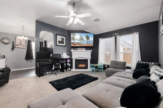 a living room with furniture a fireplace and a flat screen tv