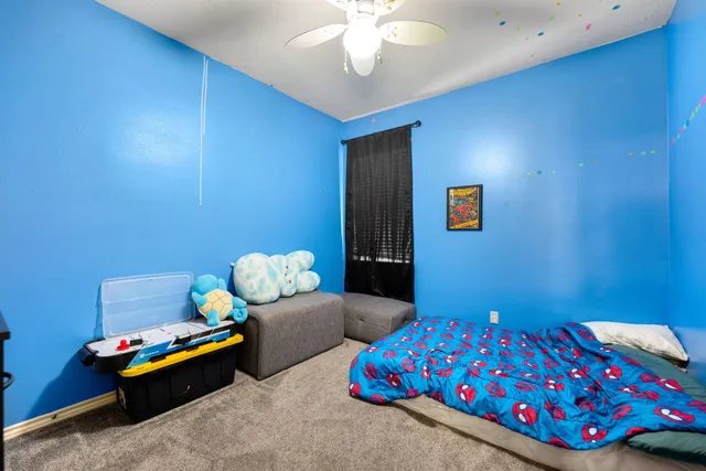 a bedroom with a bed flat screen tv and a large window