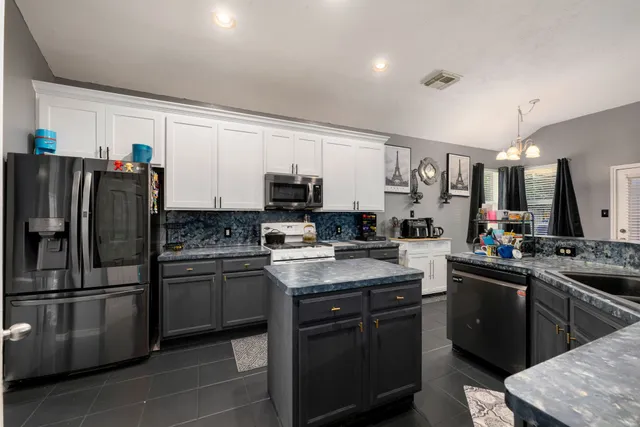 a kitchen with stainless steel appliances granite countertop a refrigerator stove a sink and dishwasher