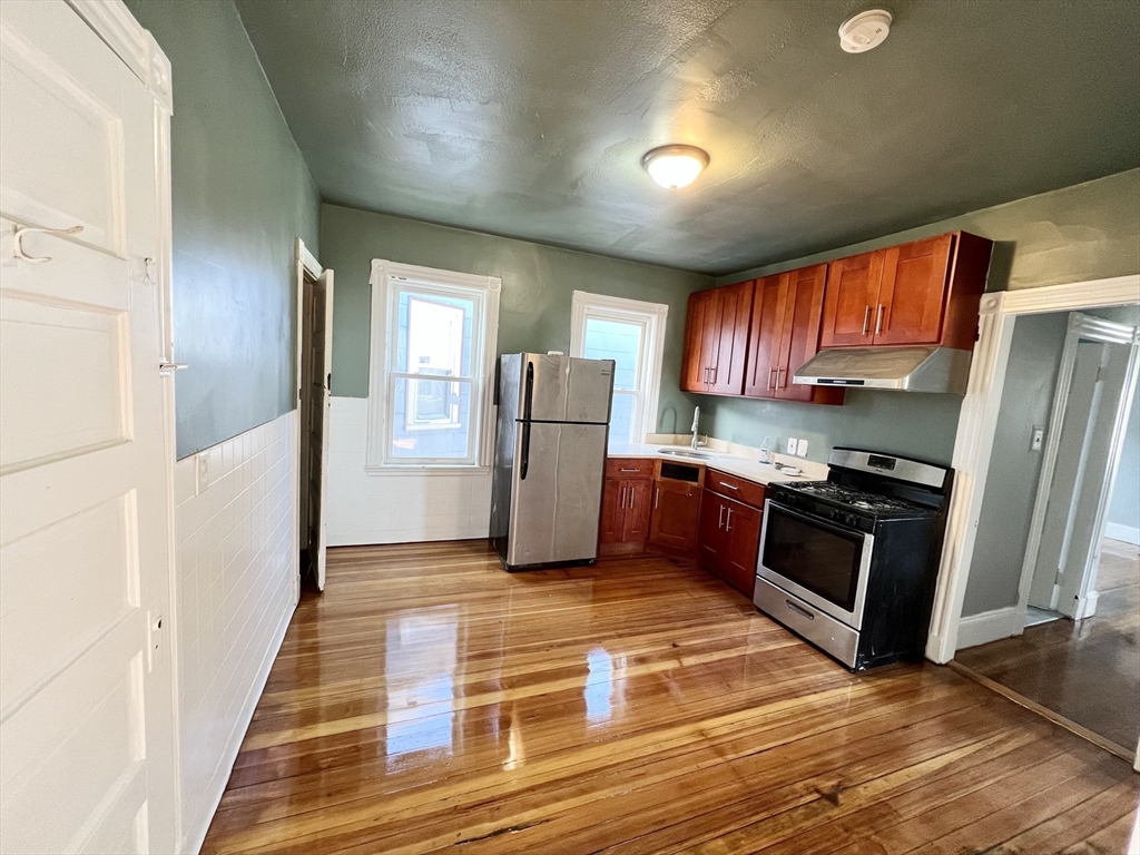 6 Taft Street, Unit 1 Boston, MA 02125 - Photo 2 of 10 a kitchen with stainless steel appliances granite countertop a refrigerator and a stove