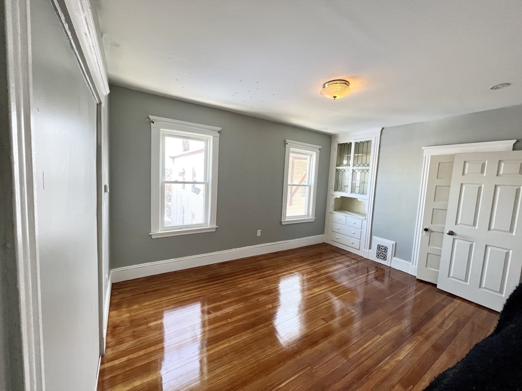 6 Taft Street, Unit 1 Boston, MA 02125 - Photo 5 of 10 a view of an empty room with wooden floor and a window