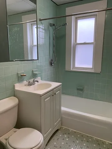 a bathroom with a sink a toilet a mirror a bathtub and shower