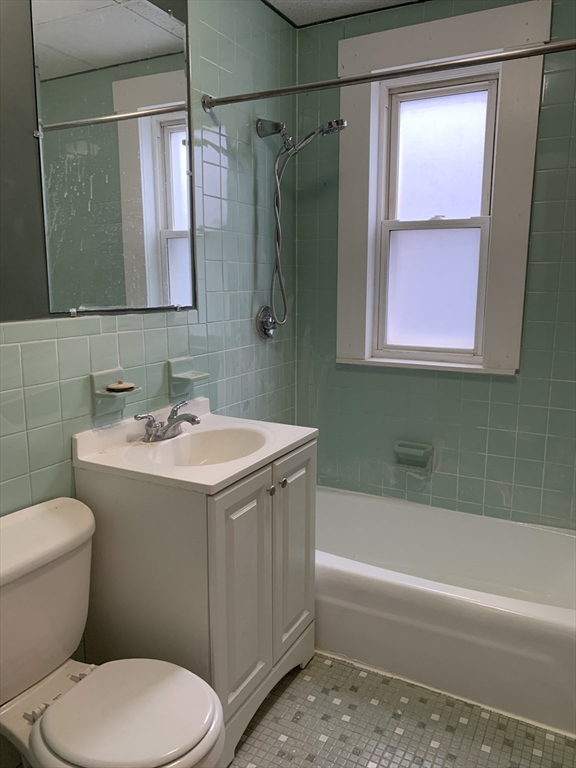 6 Taft Street, Unit 1 Boston, MA 02125 - Photo 7 of 10 a bathroom with a sink a toilet a mirror a bathtub and shower