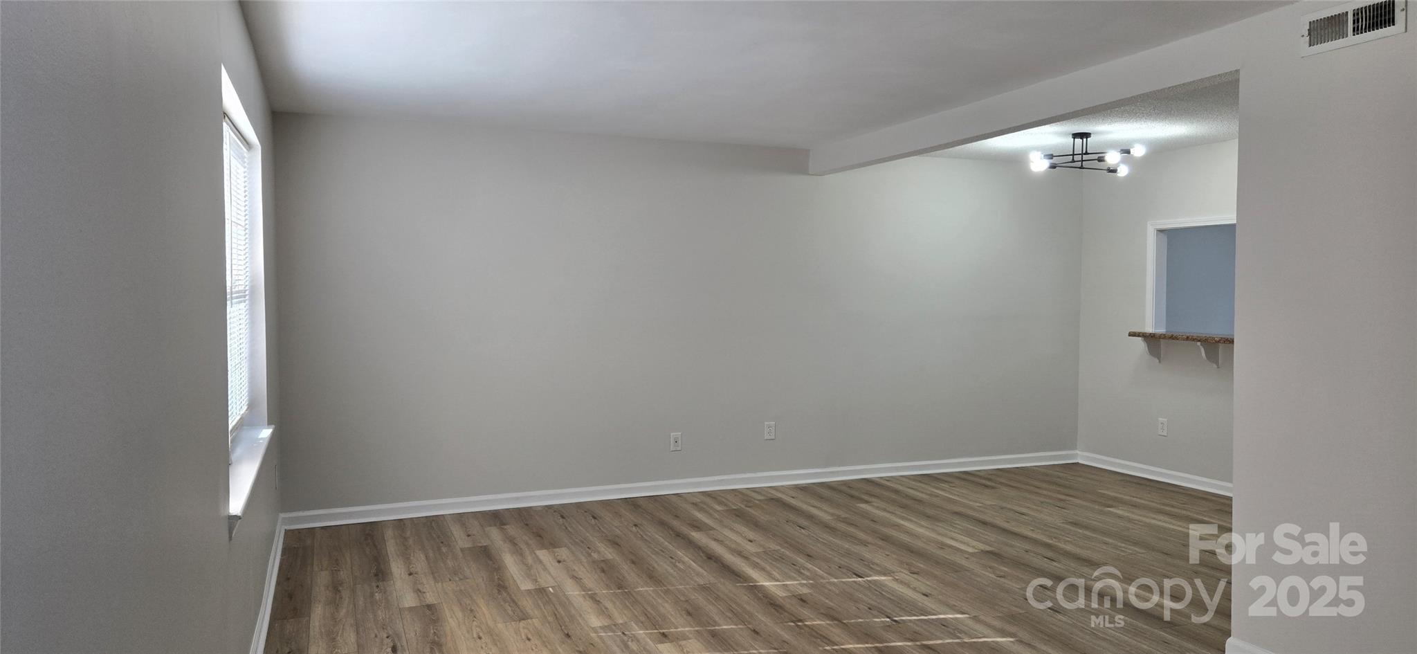 11011 Park Road Charlotte, NC 28226 - Photo 4 of 22 a view of an empty room with wooden floor and a window