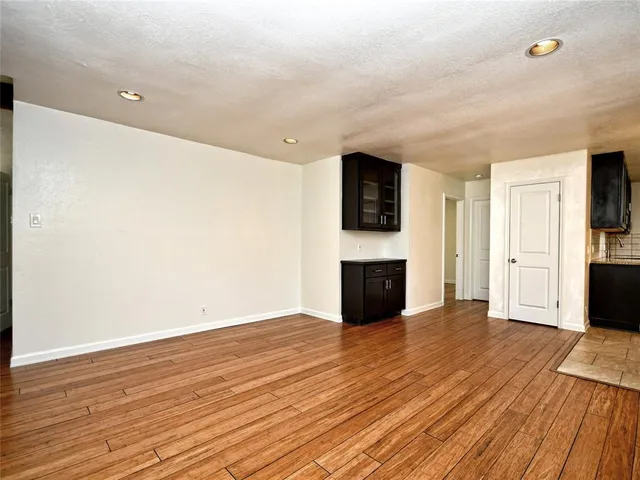 a view of empty room with wooden floor and fireplace