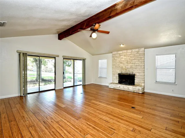 a view of empty room with wooden floor and fireplace