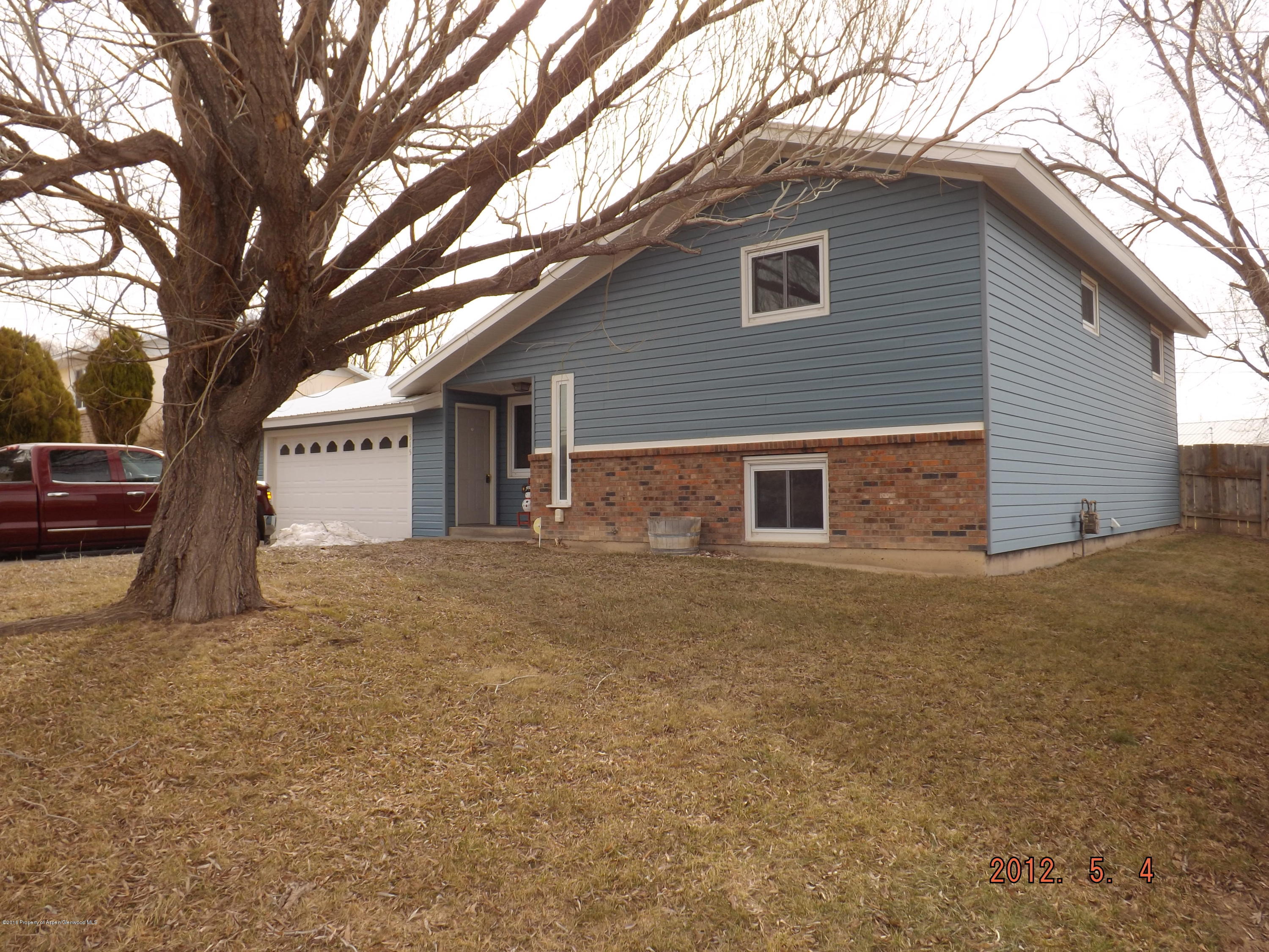 515 East 12th Street Rifle, CO 81650 - Photo 1 of 39 a backyard of a house with large trees and brick wall