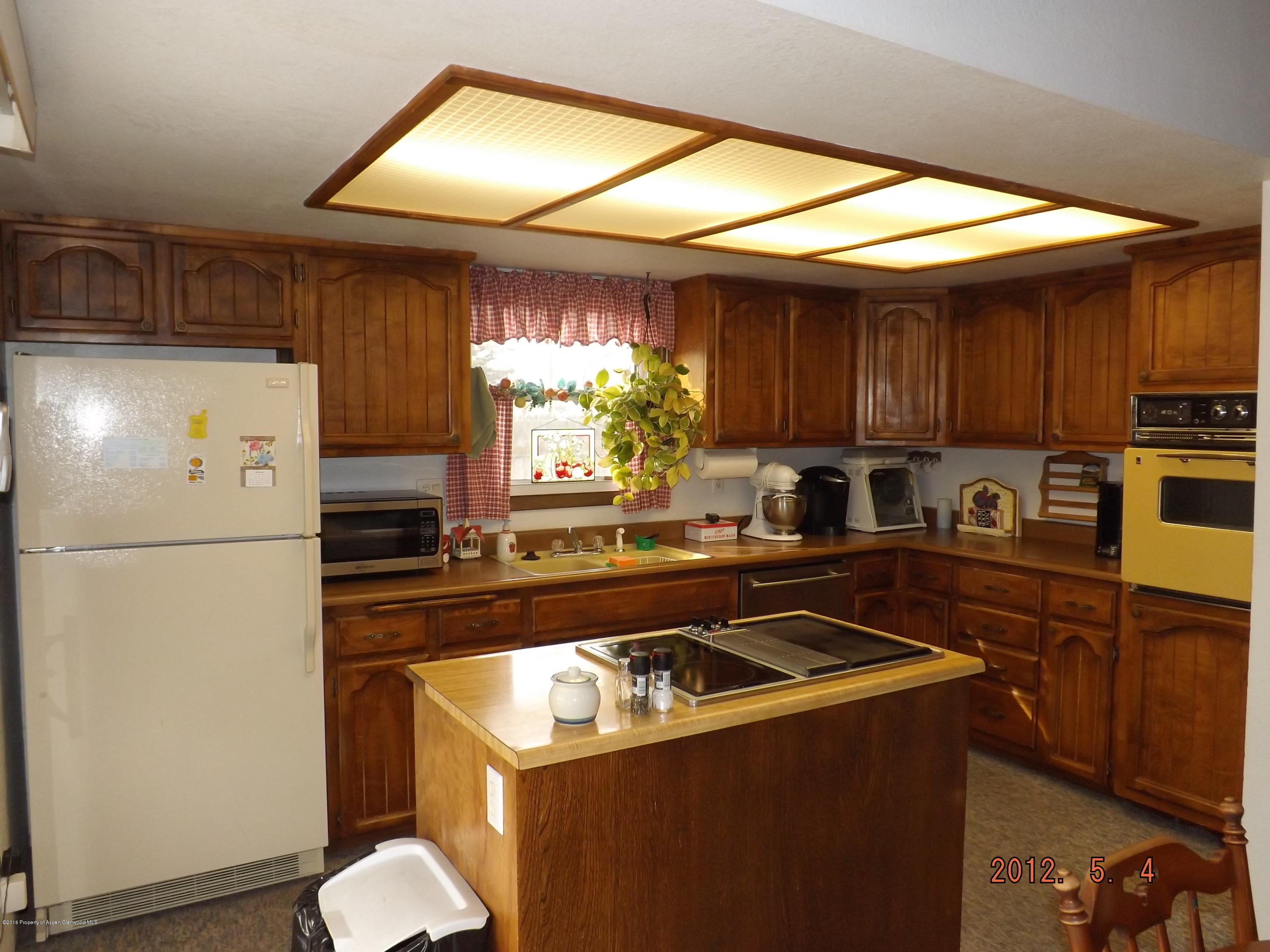 515 East 12th Street Rifle, CO 81650 - Photo 13 of 39 a kitchen with a refrigerator a stove a sink dishwasher and wooden cabinets with wooden floor
