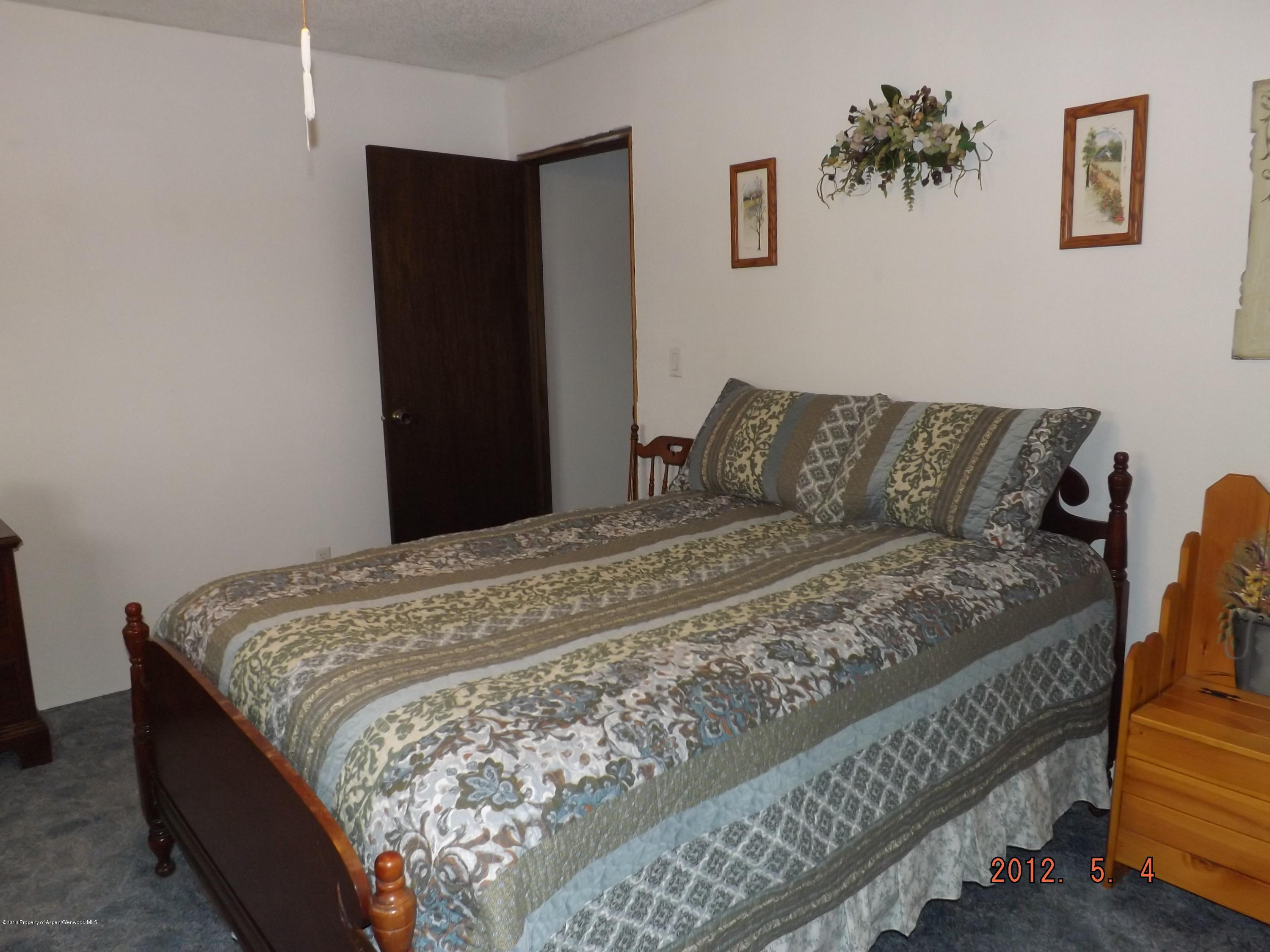 515 East 12th Street Rifle, CO 81650 - Photo 23 of 39 a bed sitting in a bedroom and a wooden floor