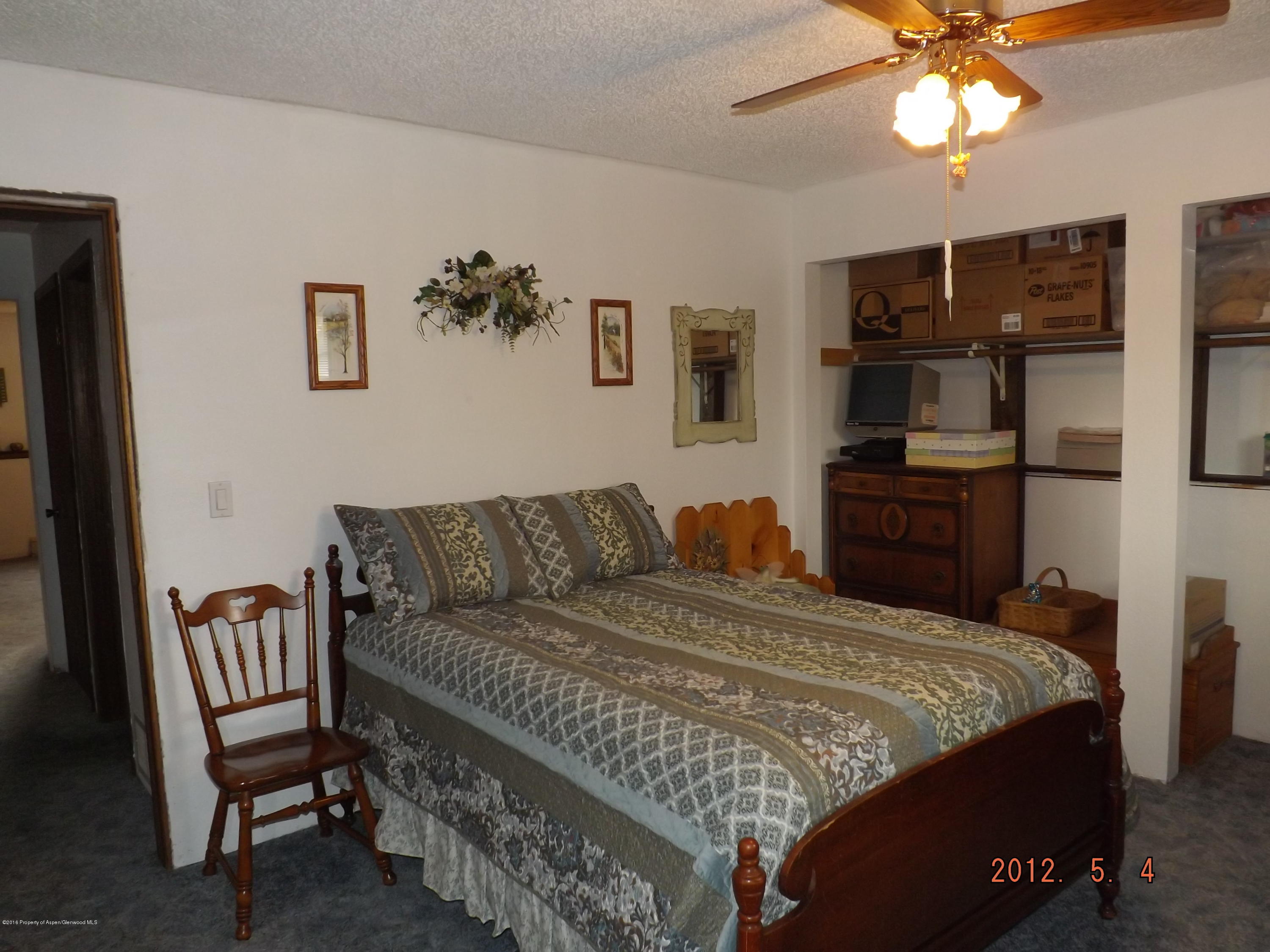 515 East 12th Street Rifle, CO 81650 - Photo 24 of 39 a bedroom with a bed and a chandelier