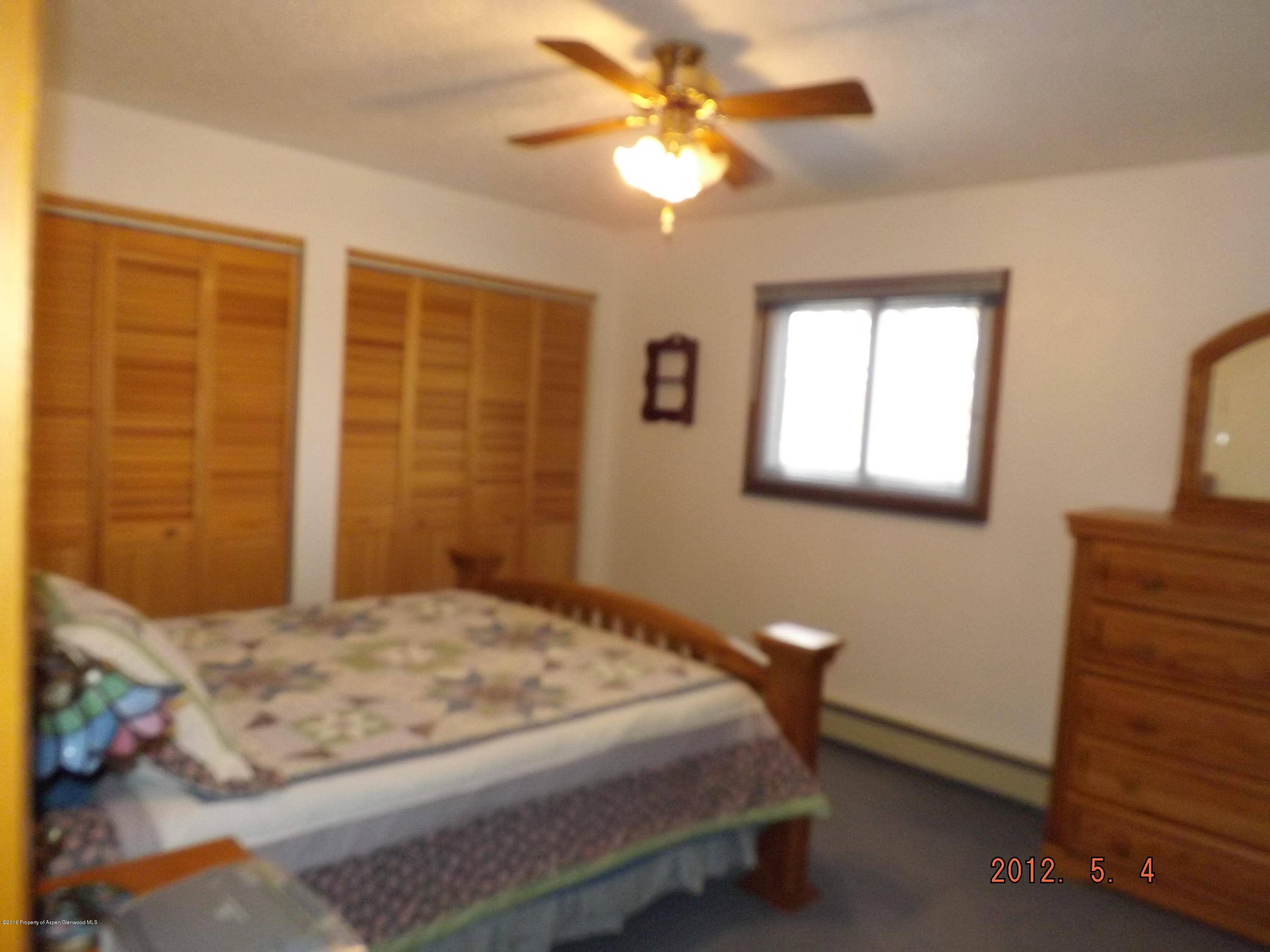515 East 12th Street Rifle, CO 81650 - Photo 26 of 39 a bedroom with a bed and a chandelier