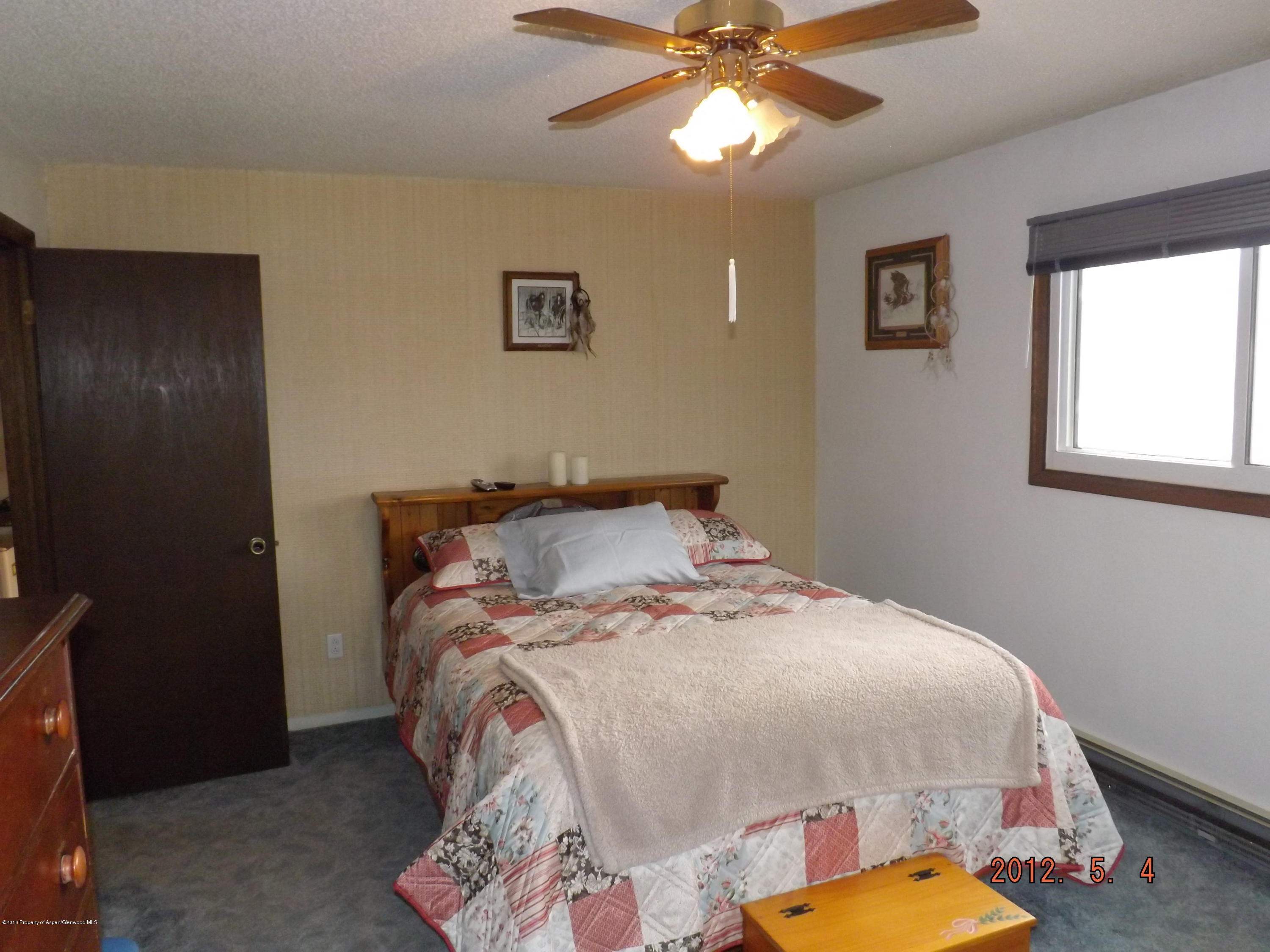 515 East 12th Street Rifle, CO 81650 - Photo 28 of 39 a bedroom with a bed and a chandelier