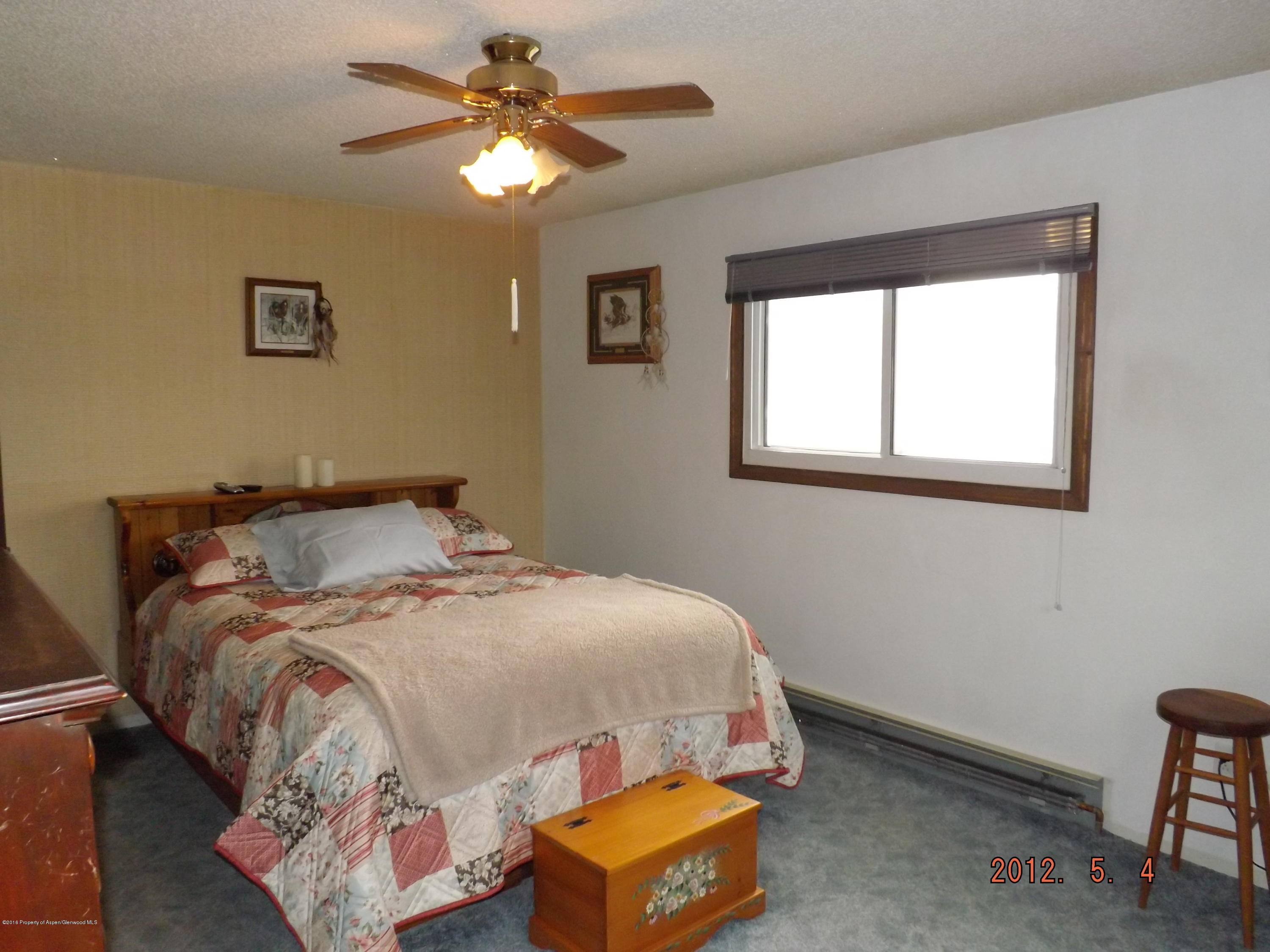 515 East 12th Street Rifle, CO 81650 - Photo 29 of 39 a bedroom with a bed and a chandelier
