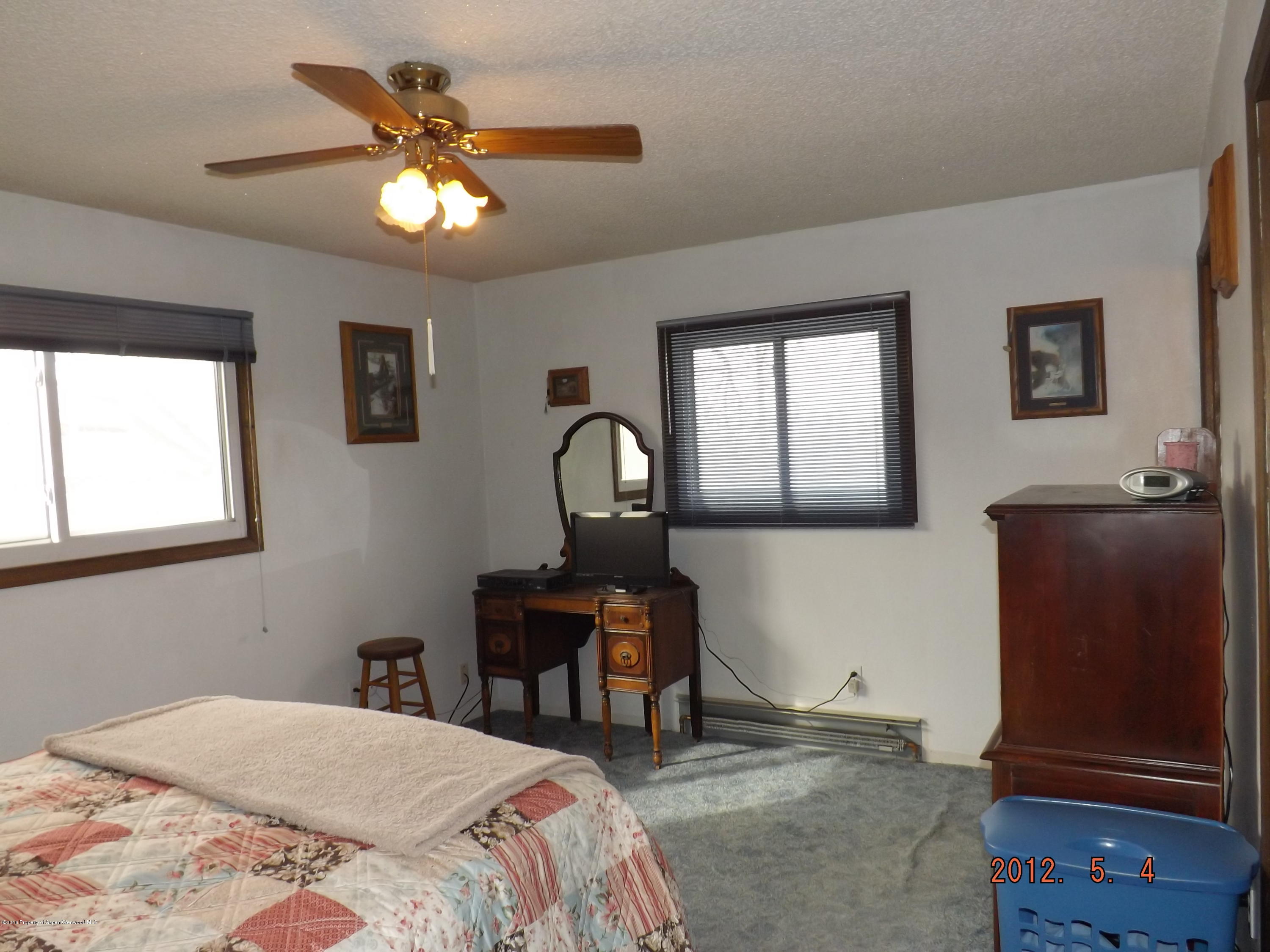 515 East 12th Street Rifle, CO 81650 - Photo 31 of 39 a bedroom with a bed and a chandelier