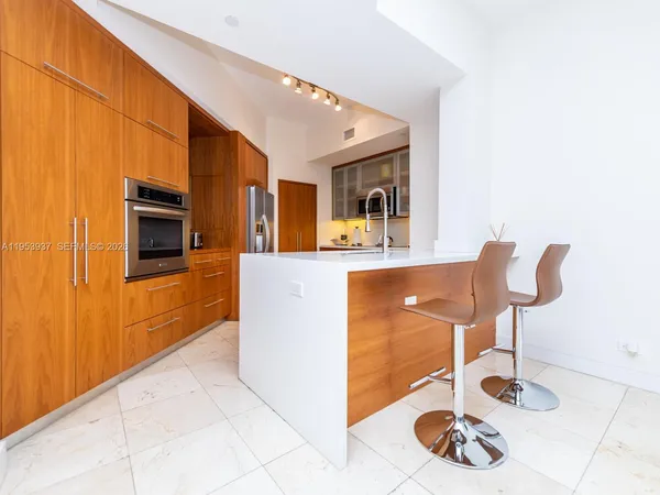 a kitchen with a refrigerator sink and cabinets