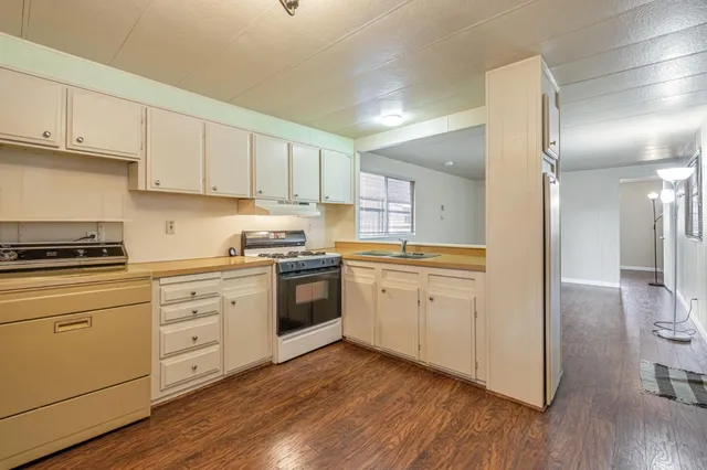 a kitchen with granite countertop white cabinets and white appliances