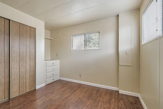 an empty room with wooden floor and closet