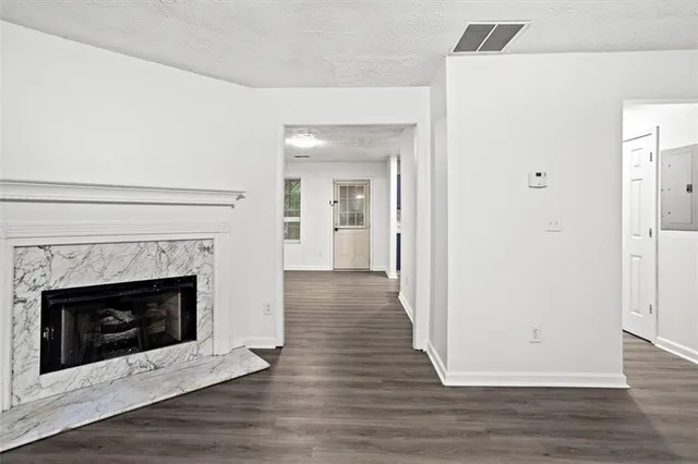 a view of a livingroom with wooden floor and a fireplace