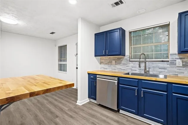a kitchen with granite countertop wooden cabinets a sink and dishwasher