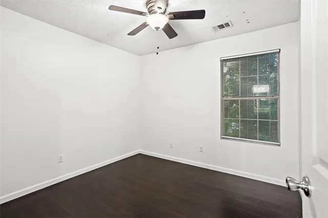 an empty room with a window and a ceiling fan