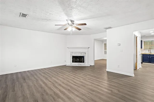 a view of empty room with wooden floor and fireplace