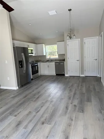 a view of a kitchen with a sink cabinets and wooden floor