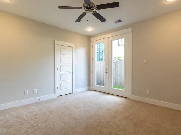 a view of an empty room and chandelier fan