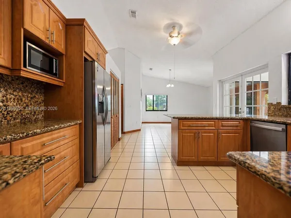 a kitchen with stainless steel appliances granite countertop a refrigerator and a stove top oven