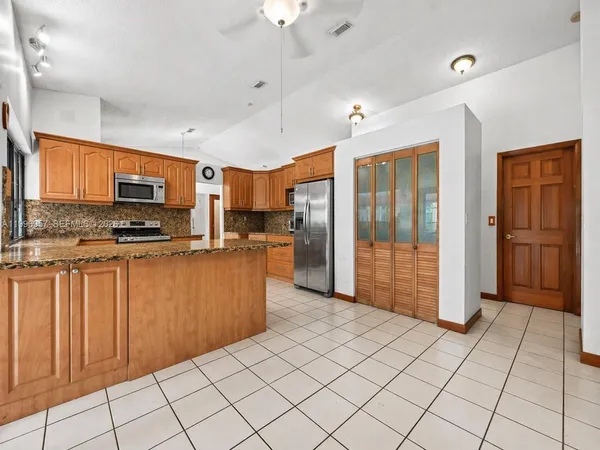 a kitchen with stainless steel appliances granite countertop a stove a sink and a microwave