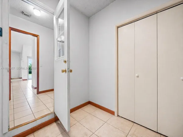 a view of an empty room with window and a ceiling fan