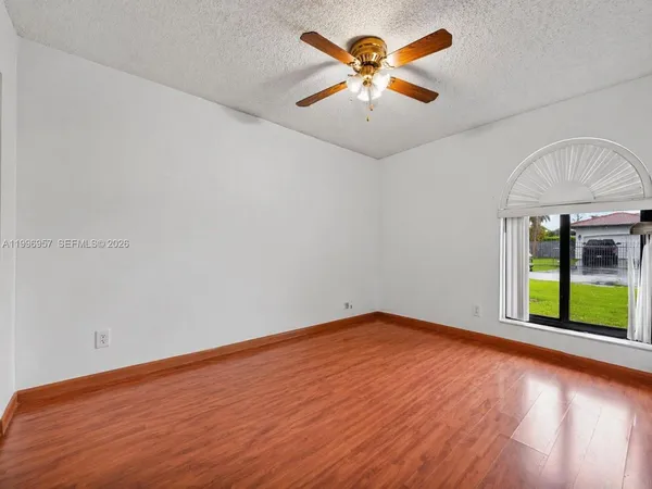a view of an empty room with a floor to ceiling window and a yard