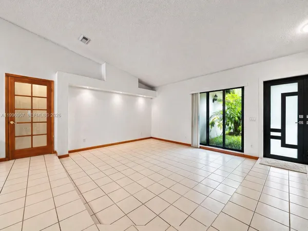 a view of a livingroom with a chandelier fan and windows