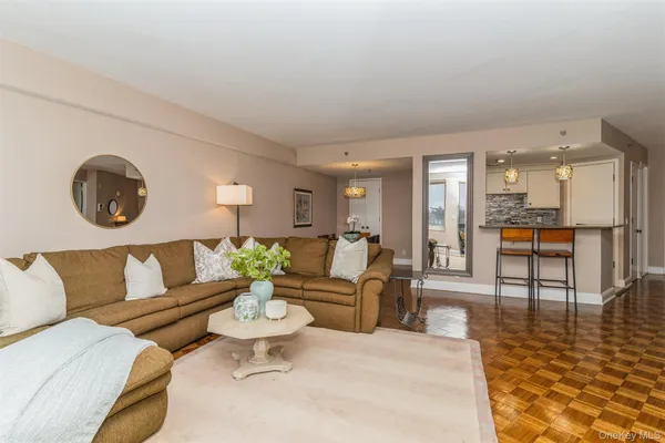 a living room with furniture and a view of kitchen