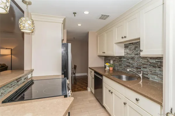 a kitchen with stainless steel appliances granite countertop a sink and a stove