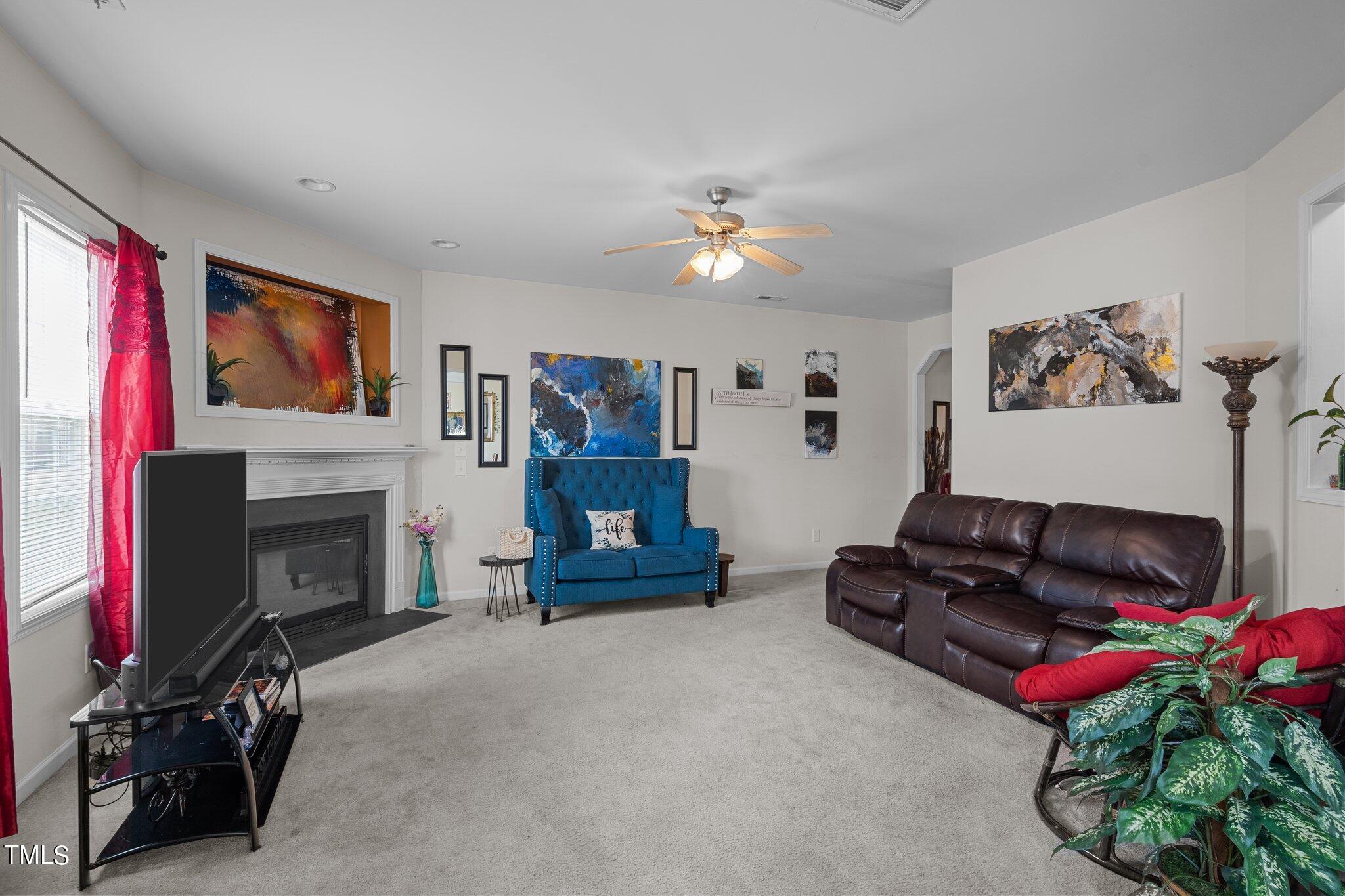 3930 Evans Drive Raleigh, NC 27610 - Photo 11 of 44 a living room with furniture a fireplace and a flat screen tv