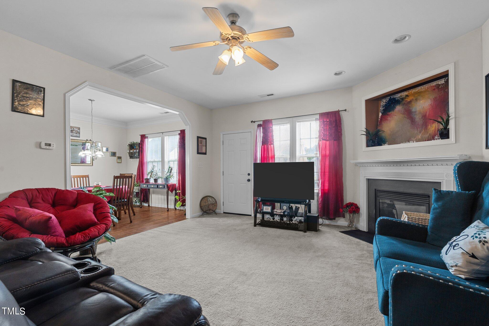 3930 Evans Drive Raleigh, NC 27610 - Photo 14 of 44 a living room with furniture a fireplace and a flat screen tv