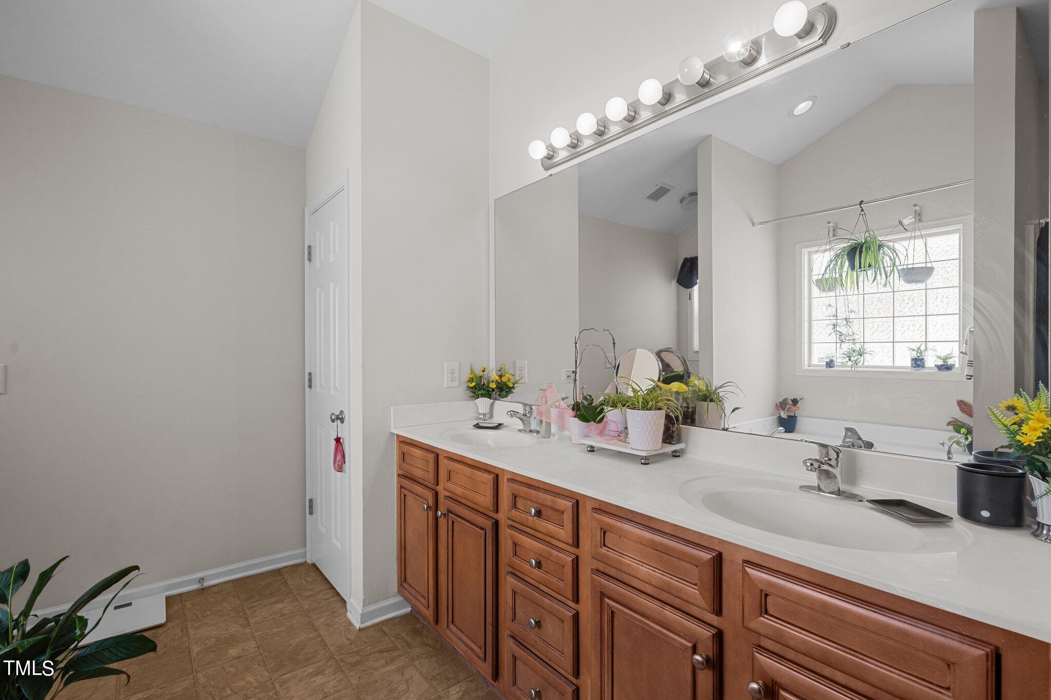 3930 Evans Drive Raleigh, NC 27610 - Photo 21 of 44 a bathroom with double vanity and a mirror
