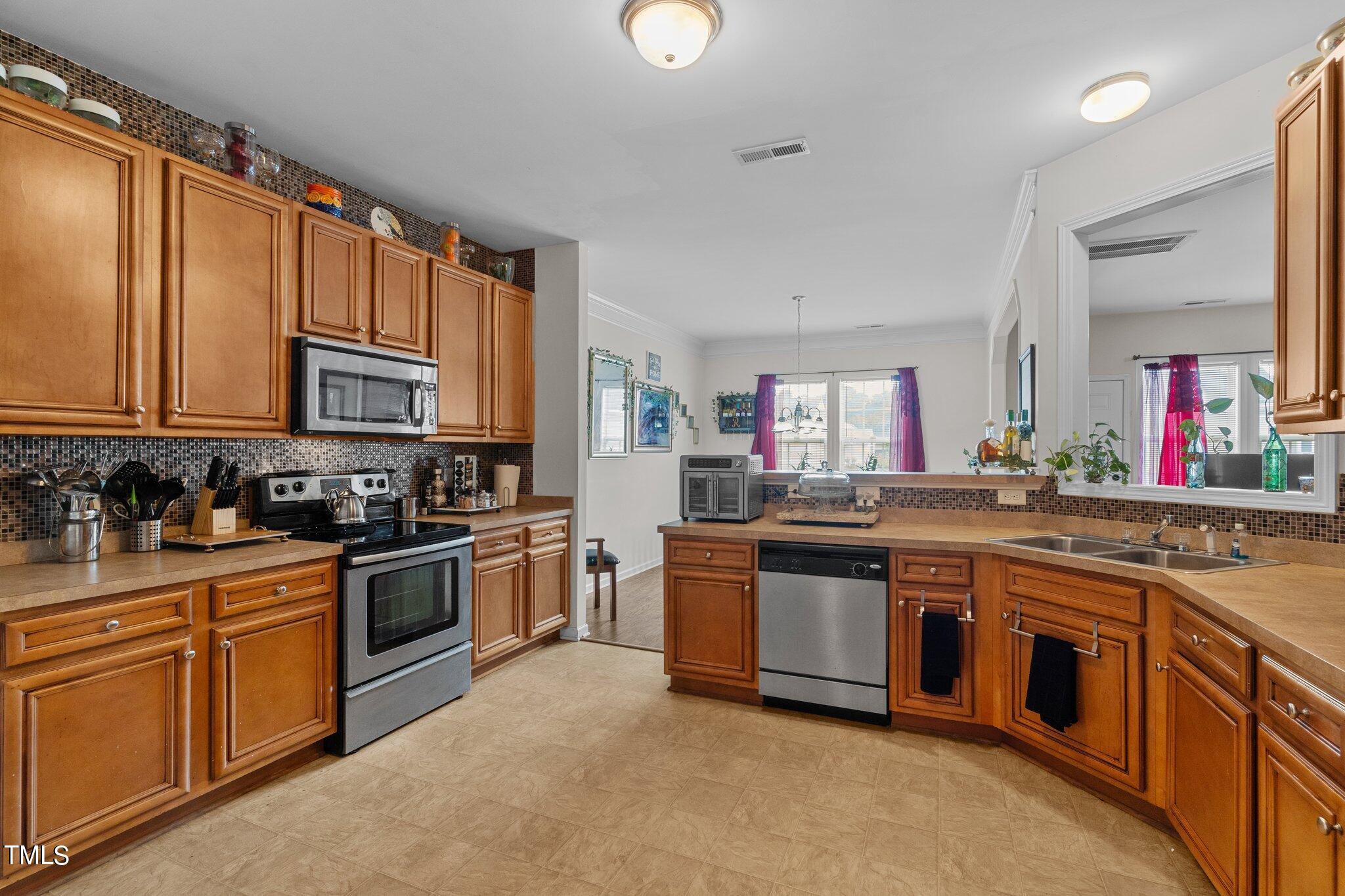 3930 Evans Drive Raleigh, NC 27610 - Photo 5 of 44 a kitchen with stainless steel appliances granite countertop a stove top oven sink and cabinets