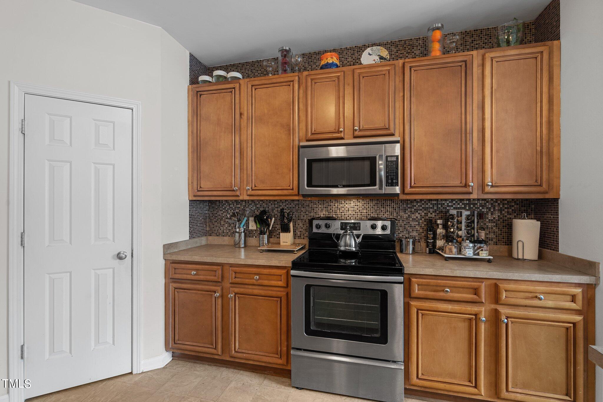 3930 Evans Drive Raleigh, NC 27610 - Photo 6 of 44 a kitchen with stainless steel appliances wooden cabinets and a stove top oven