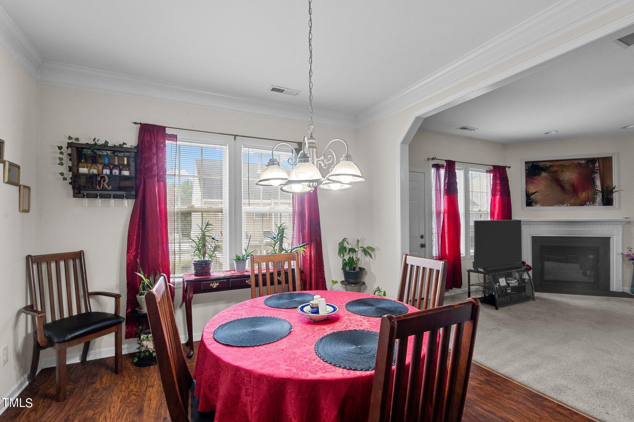 3930 Evans Drive Raleigh, NC 27610 - Photo 8 of 44 a dining room with furniture a chandelier and window