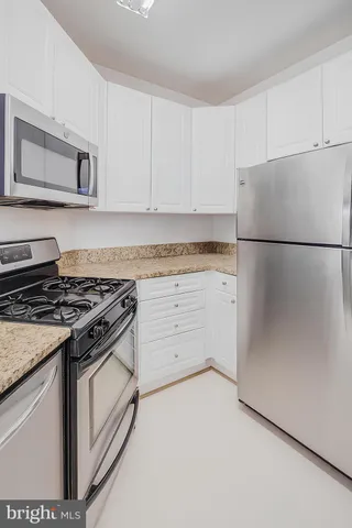 a kitchen with white cabinets and white appliances