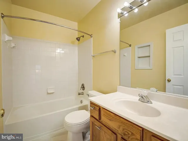 a bathroom with a granite countertop sink a toilet and shower