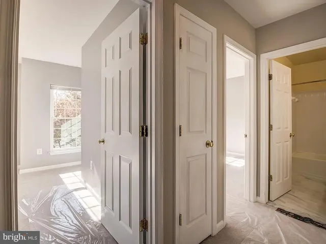a view of a bedroom with wooden floor and a bathroom