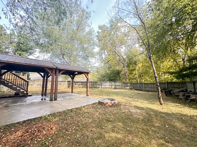 a view of a yard with wooden fence