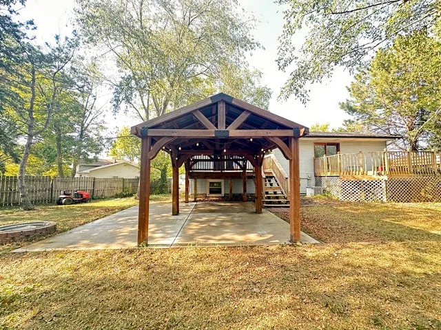 a view of a house with a yard and large tree